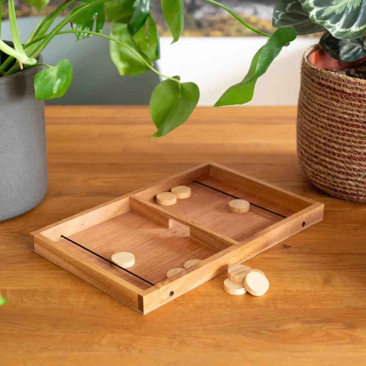 Houten strategie spel met schijven op houten tafel, omringd door planten