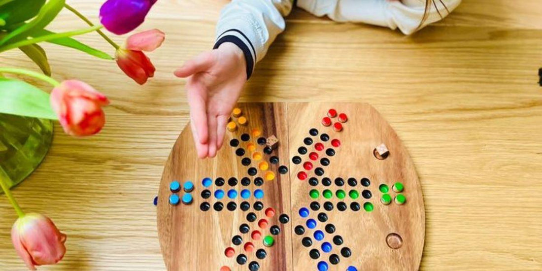 Houten strategiebordspel met kleurrijke pionnen, geschikt voor jong en oud, op houten tafel met tulpen