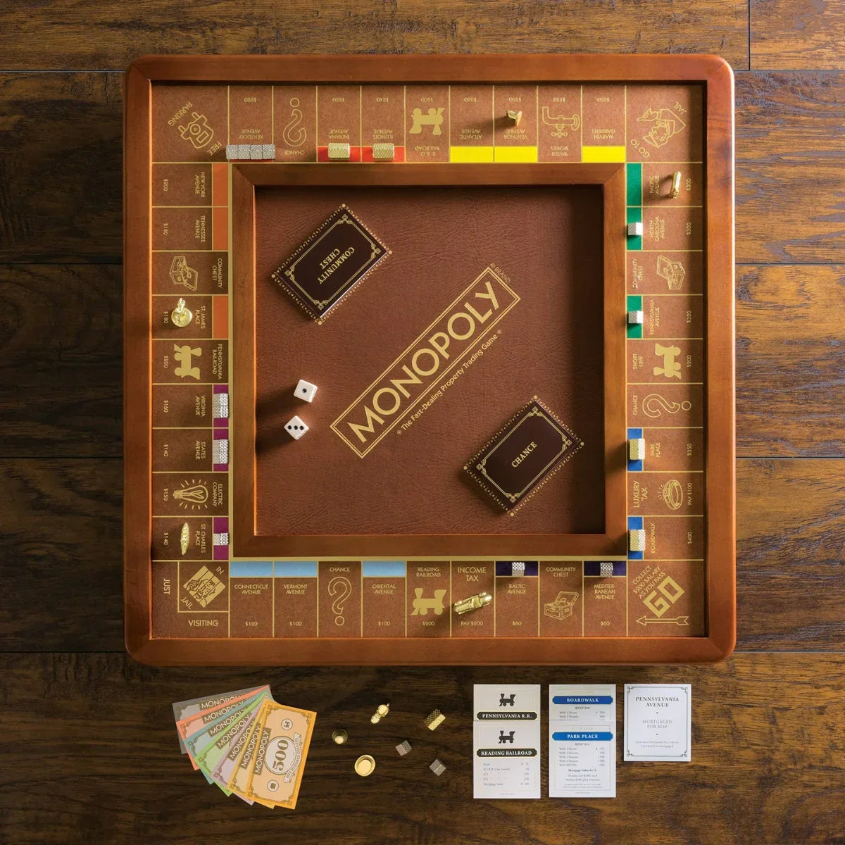Luxury wooden Monopoly board game with gold details, dice, cards, and tokens on rustic wood table